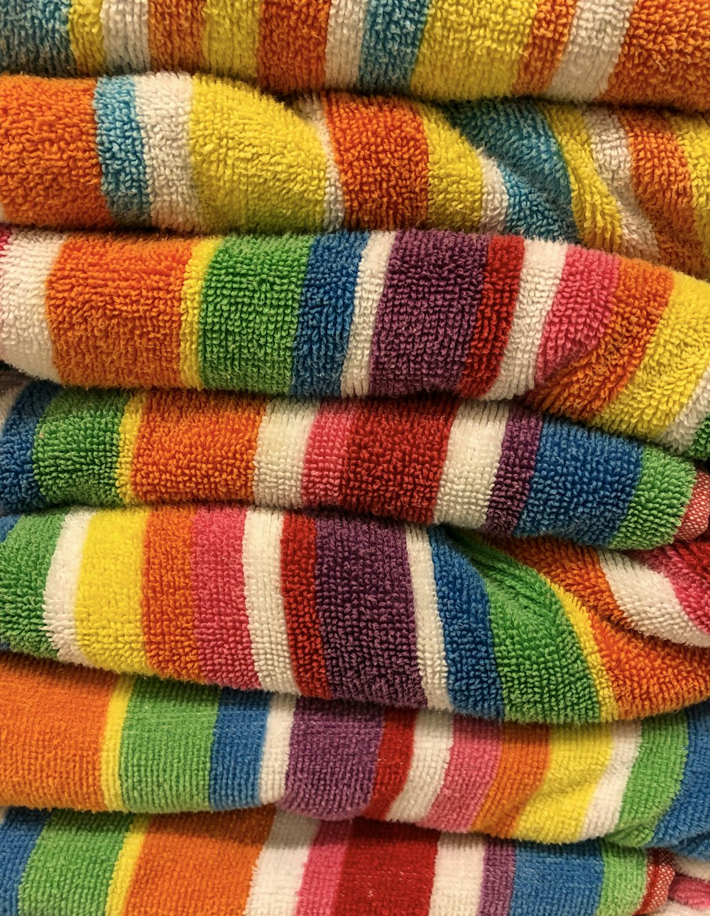 a stack of multicolored towels sitting on top of each other