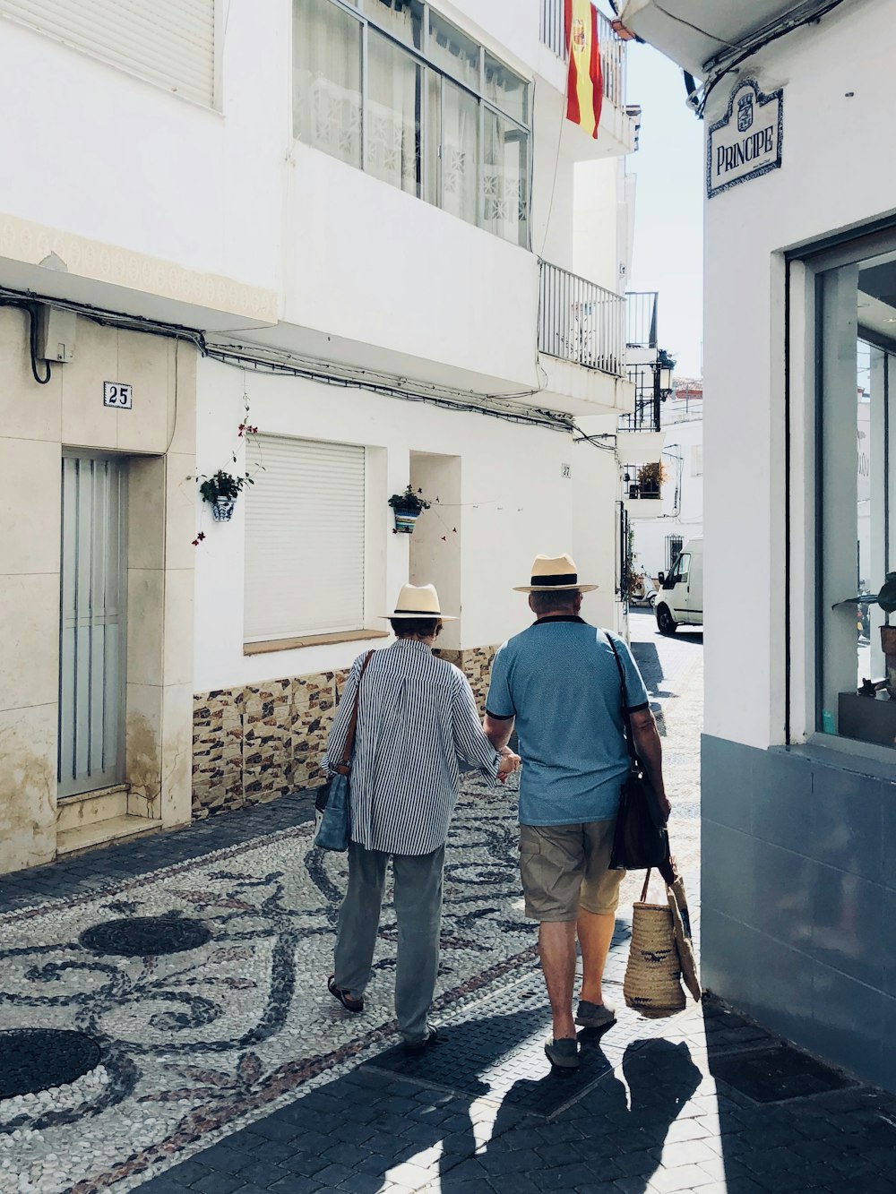 2 men walking on sidewalk during daytime