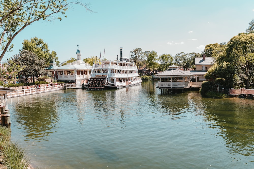 white boat on river near green trees during daytime