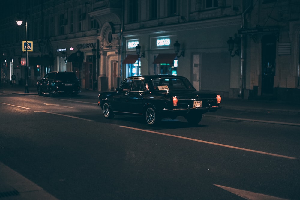sedán negro en la carretera durante la noche