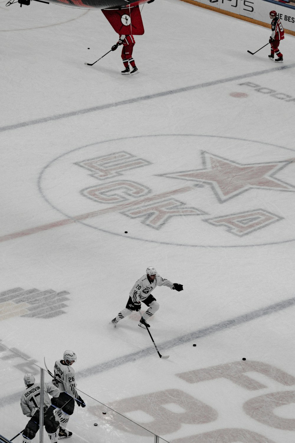 man in white ice hockey jersey shirt and black pants playing hockey