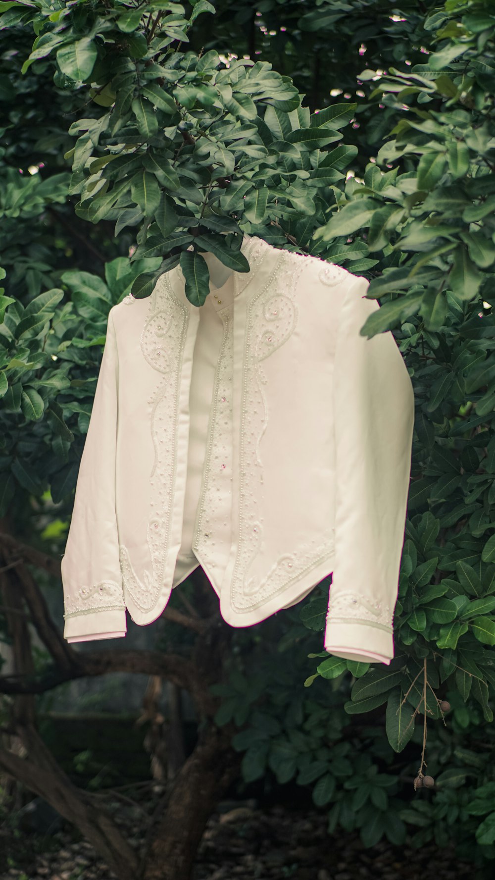 white floral textile on green plant