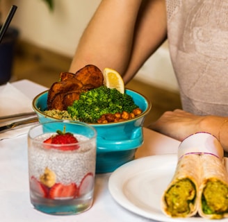 person holding green vegetable on white ceramic plate