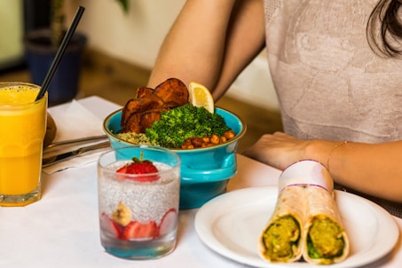 person holding green vegetable on white ceramic plate