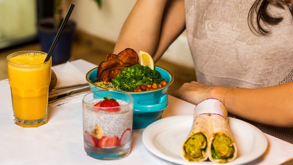 person holding green vegetable on white ceramic plate