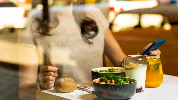 A friendly nutritionist consulting with a happy client using a tablet displaying a personalized meal plan.