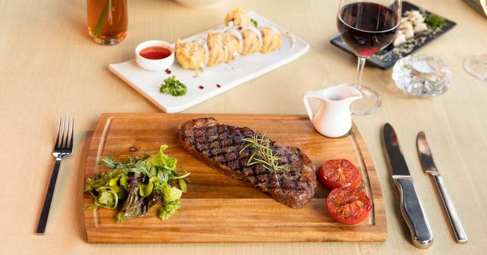 Carne a la parrilla en tabla de cortar de madera marrón