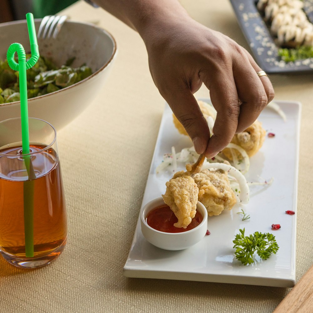 person holding white ceramic bowl with food