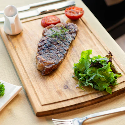 Grilled meat on a wooden chopping board, evoking a locavore grill restaurant
