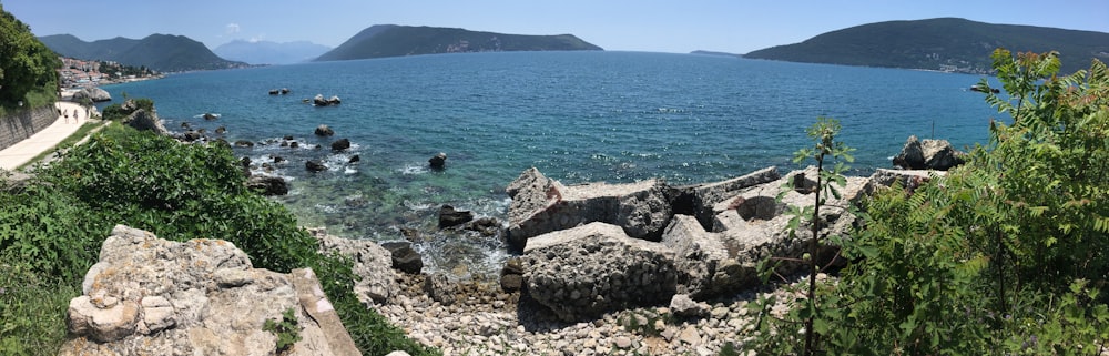 costa rochosa cinzenta com mar azul durante o dia