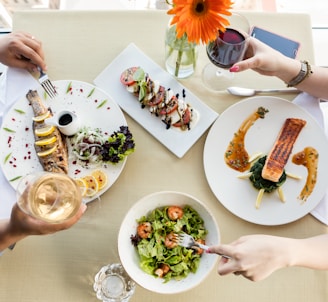 person holding fork and knife slicing vegetable on white ceramic plate