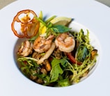 Close-up of a vibrant platter with grilled shrimp, fresh herbs, and citrus slices.