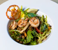 Elegant plating of a savory brunch dish featuring grilled shrimp and mango salsa.
