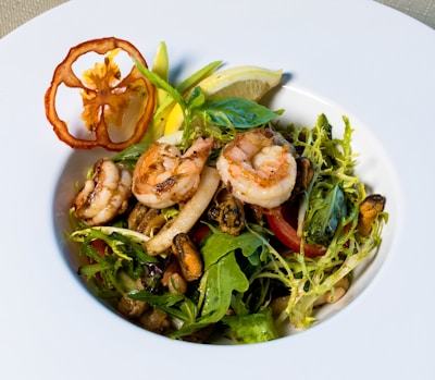 A vibrant seafood dish featuring shrimp served on a rustic wooden table.