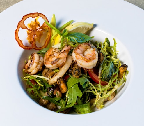 Close-up of a vibrant platter with grilled shrimp, fresh herbs, and citrus slices.