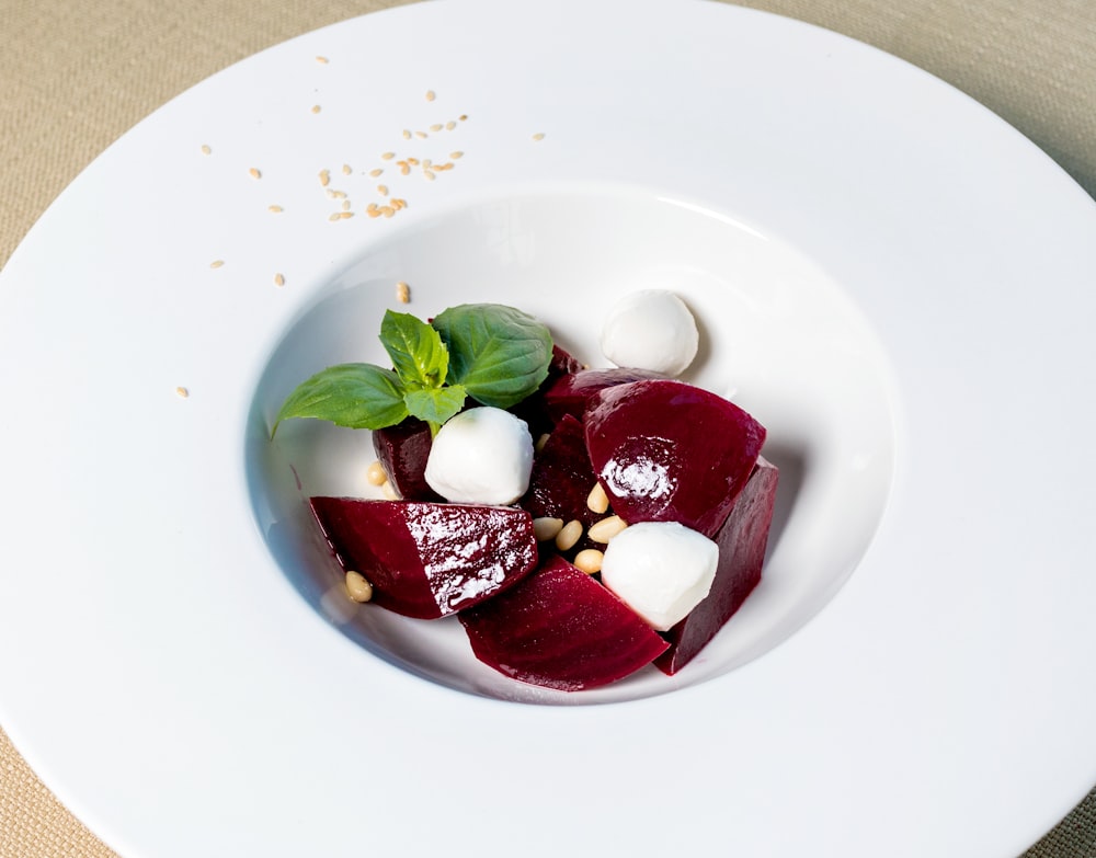 red and white sliced fruits on white ceramic plate