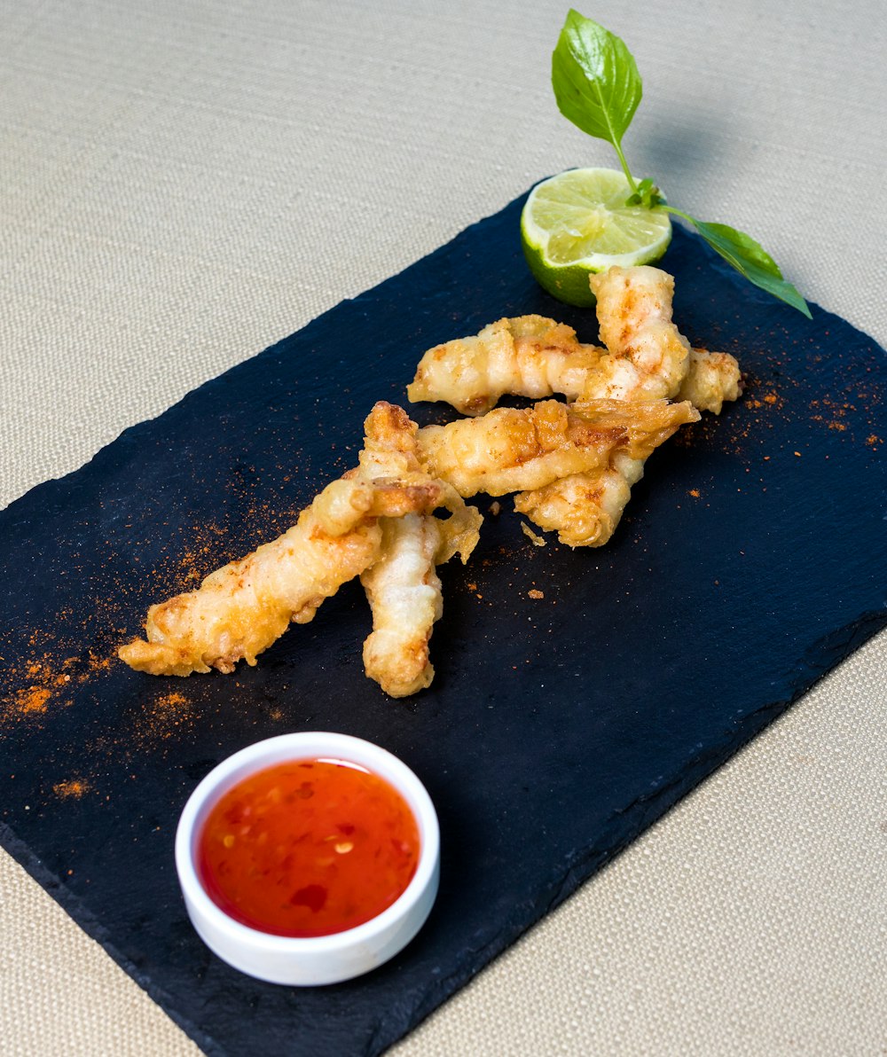 Pollo frito en plato rectangular negro