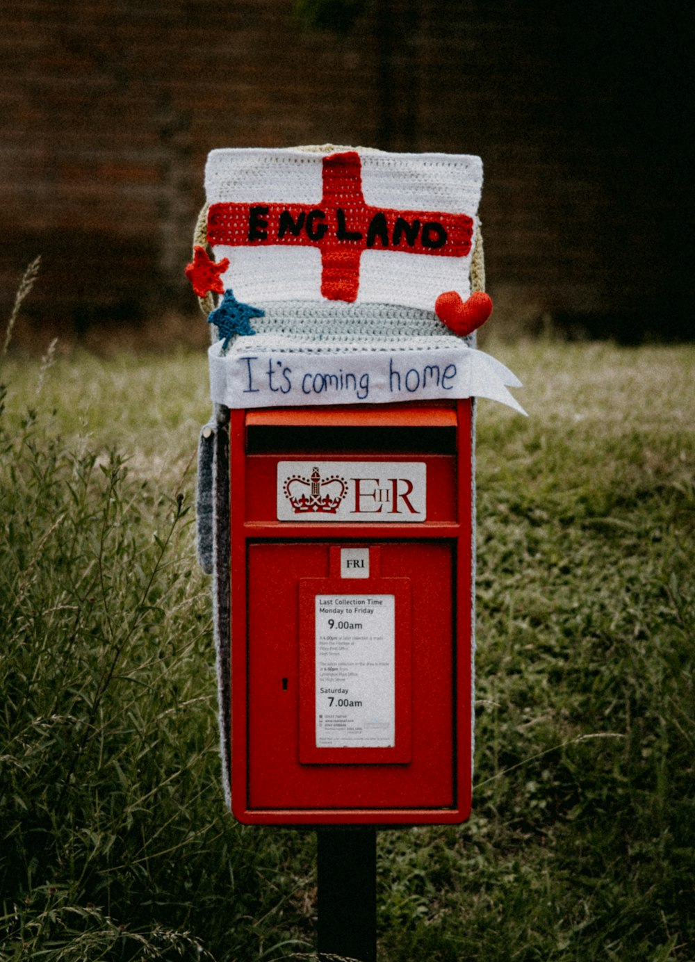 red and white mail box on green grass field