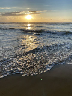 Sunset view over a serene Costa del Sol beach with gentle waves and warm golden light.