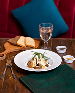 A bright, minimalist kitchen scene with fresh ingredients and a beautifully plated dish on a wooden table.