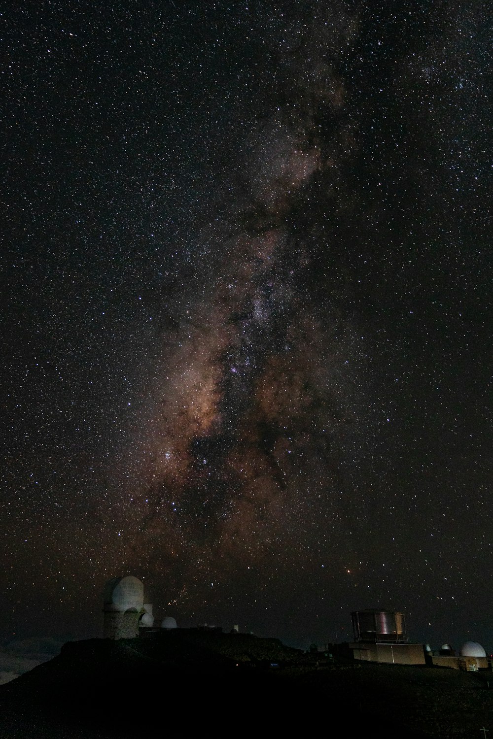 person in blue denim jeans and white sneakers standing on black and brown starry night