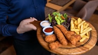 fried food with green vegetable on brown wooden round plate