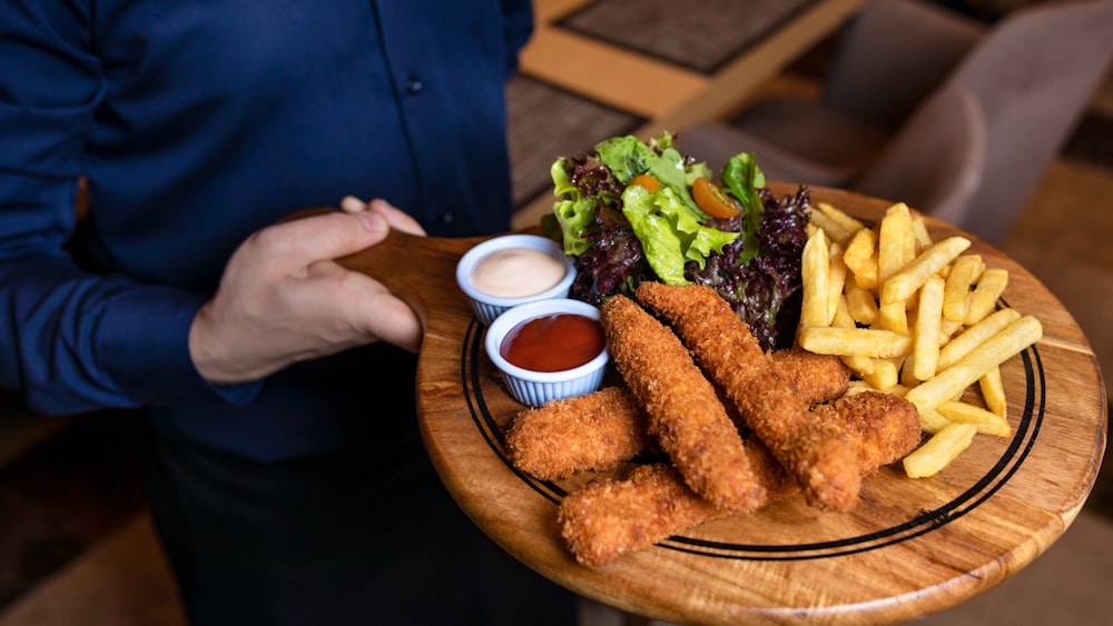 Comida frita con verdura verde en plato redondo de madera marrón