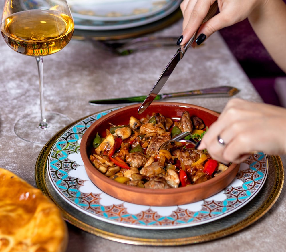 person holding stainless steel fork and spoon