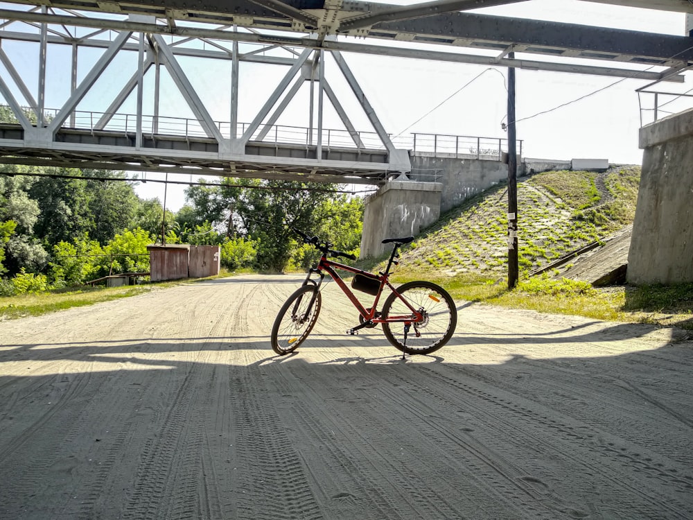 red and black bicycle on gray asphalt road during daytime