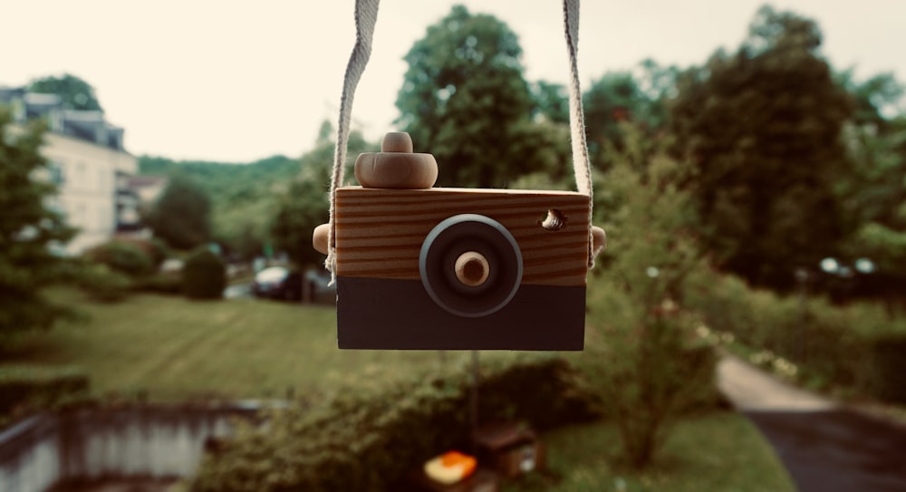 brown wooden camera hanging on gray rope