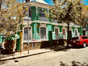 green and white concrete building near green trees during daytime