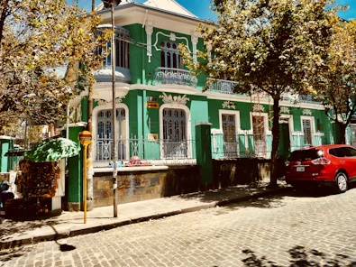 green and white concrete building near green trees during daytime