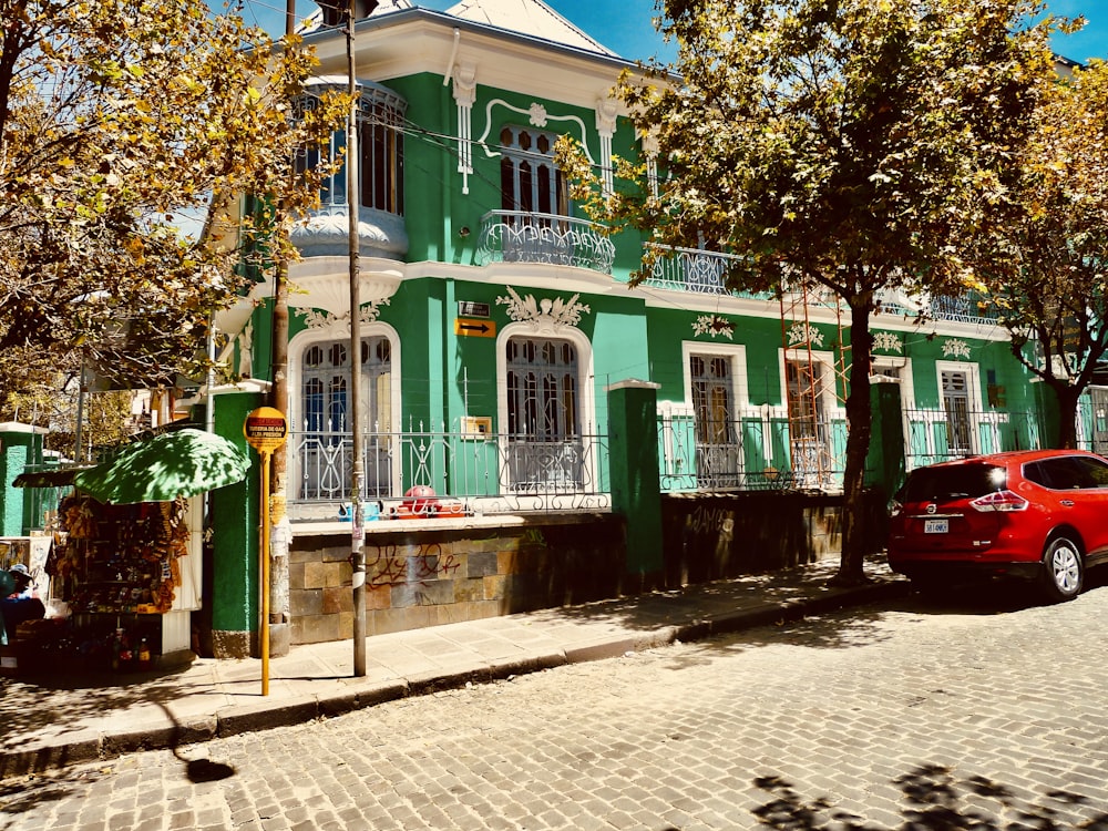 green and white concrete building near green trees during daytime