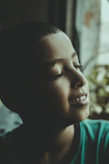 A calm child practicing mindful breathing in a sunlit room.