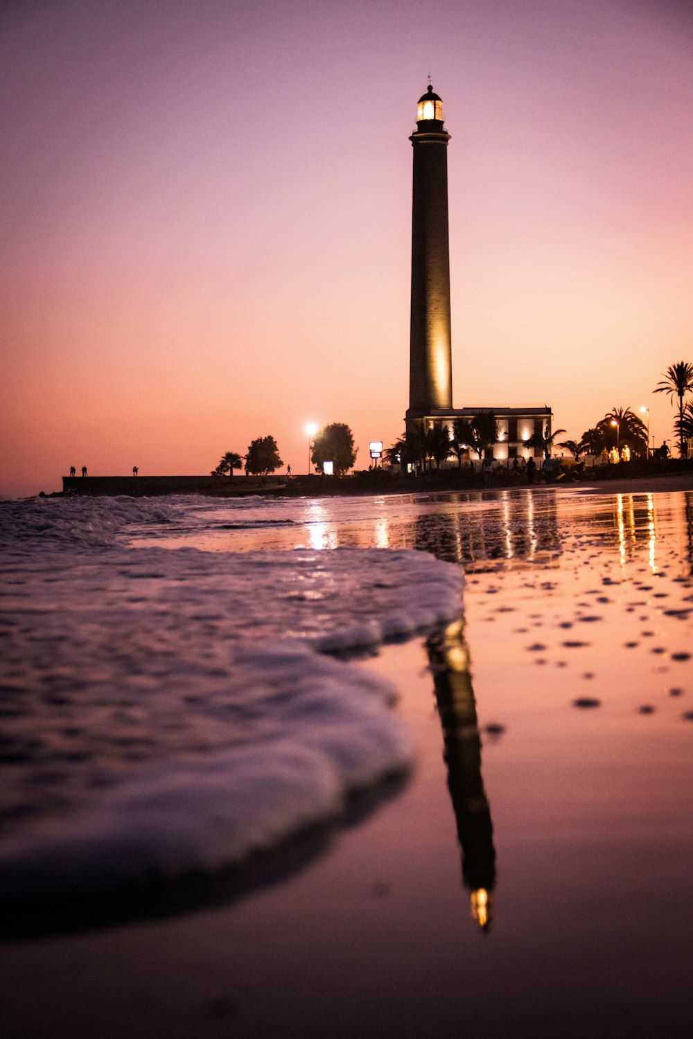 silhueta das pessoas na praia durante o pôr do sol