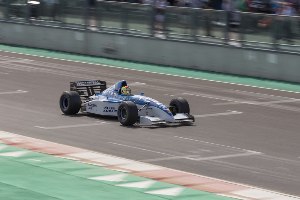 blue and white f 1 car on track