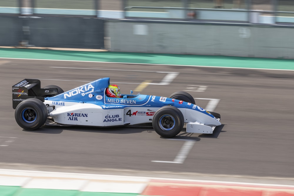 blue and white f 1 car on road