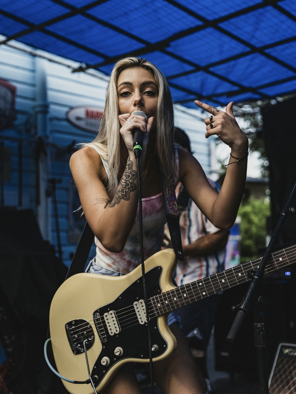 woman in black tank top singing on stage