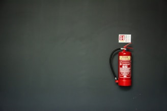 red fire extinguisher on gray wall