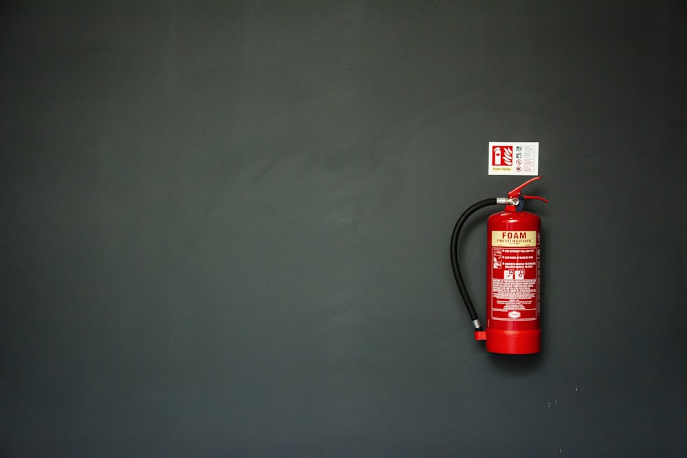 Extincteur rouge sur mur gris