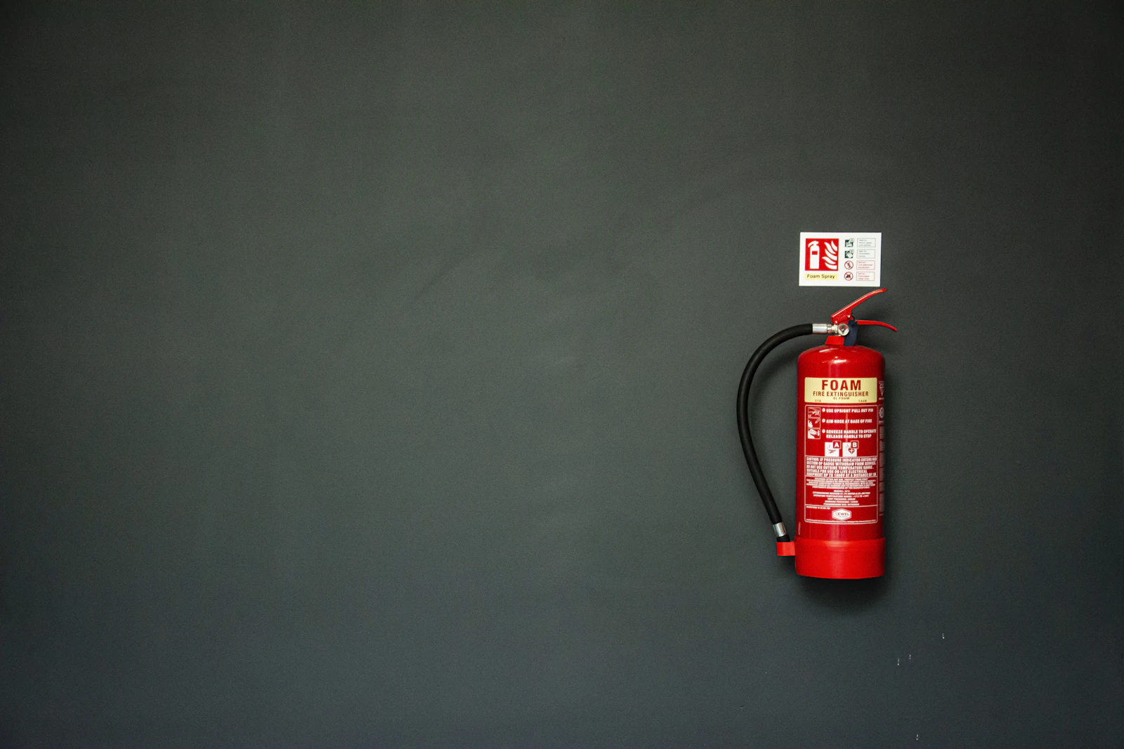 Extintor de incêndio na parede representando equipamentos de segurança no ambiente de trabalho
