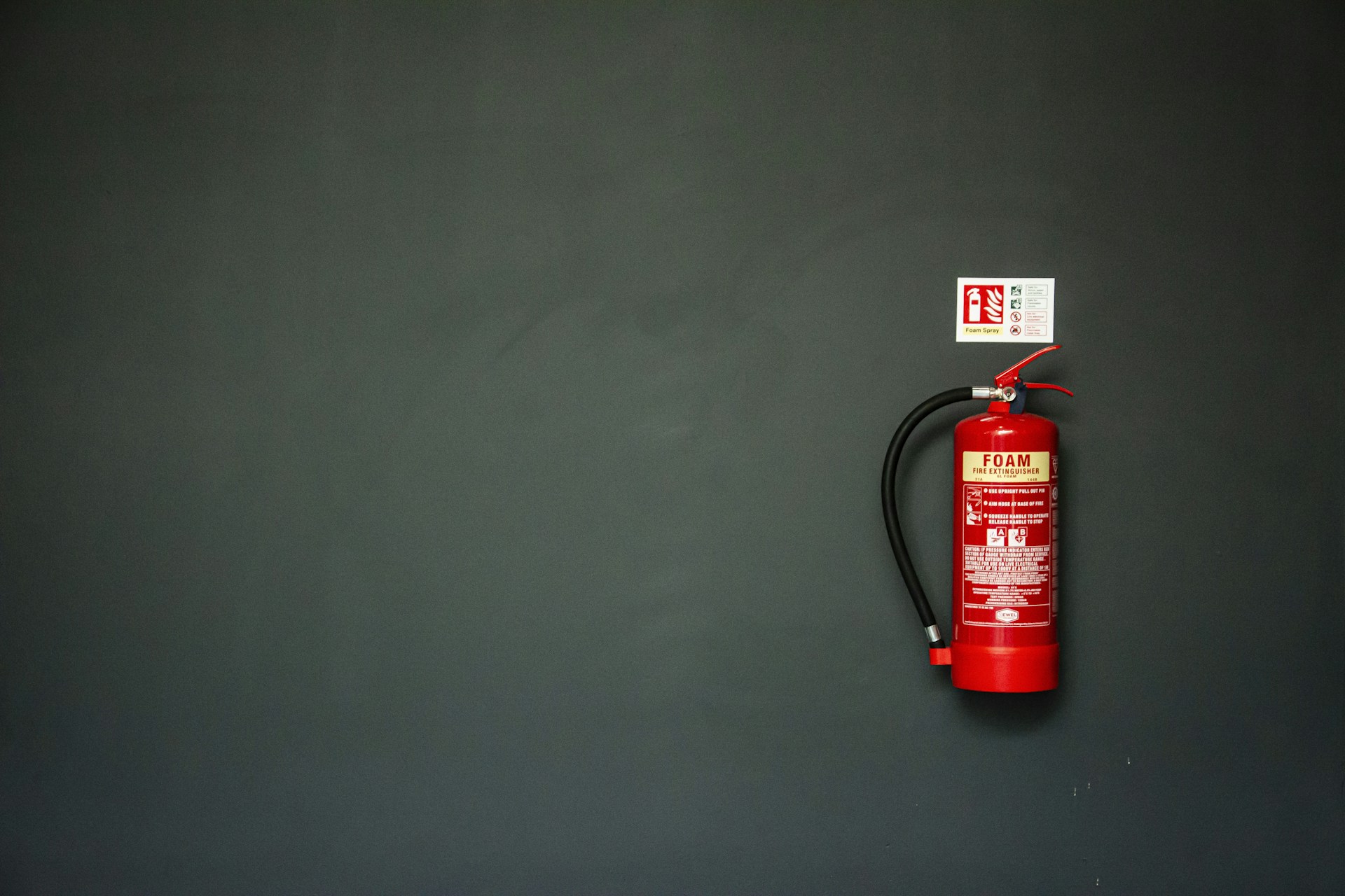 red fire extinguisher on gray wall