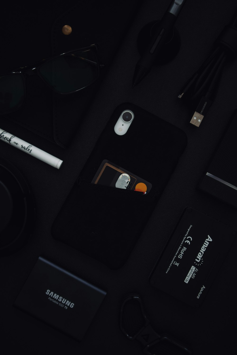 iPhone sur surface noire avec objectif de caméra blanc et noir