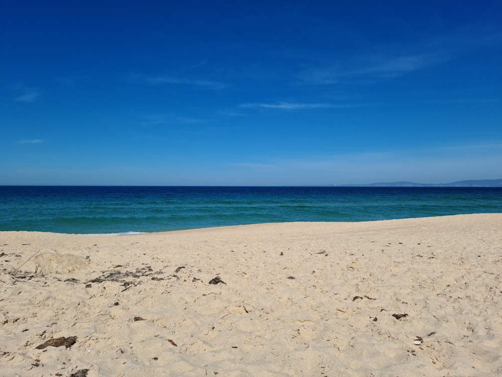 Weißer Sandstrand unter blauem Himmel tagsüber