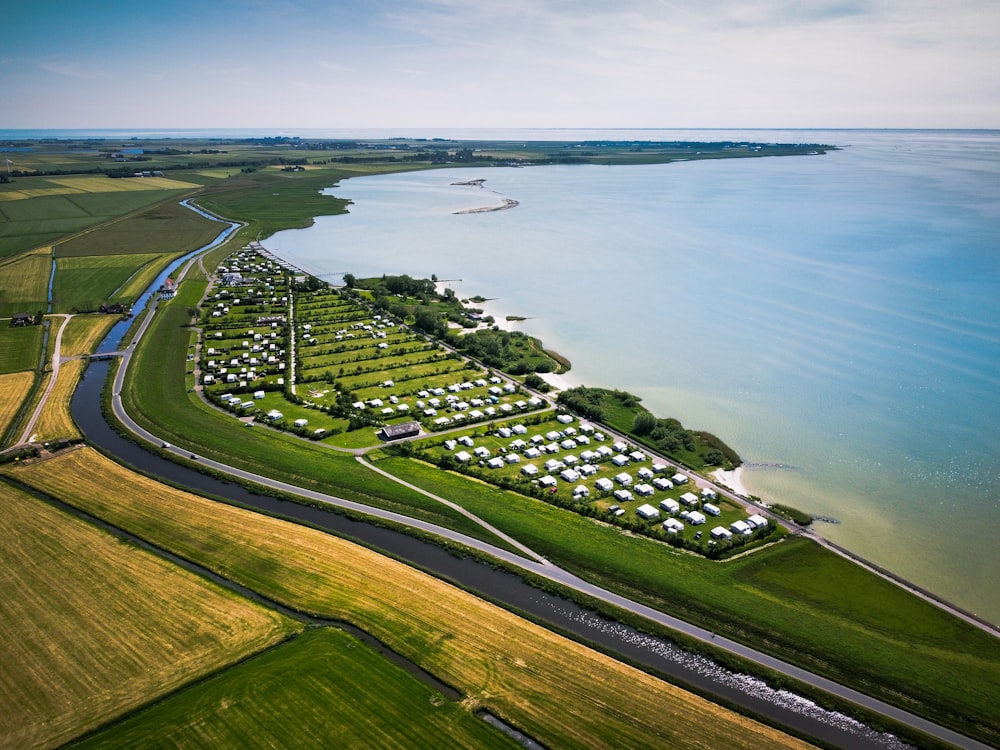 aerial view of green grass field near body of water during daytime