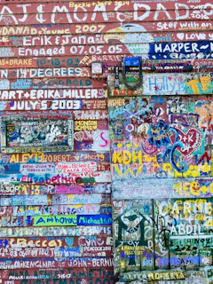 A colorful wall filled with spontaneous paint splatters and handprints from past sessions