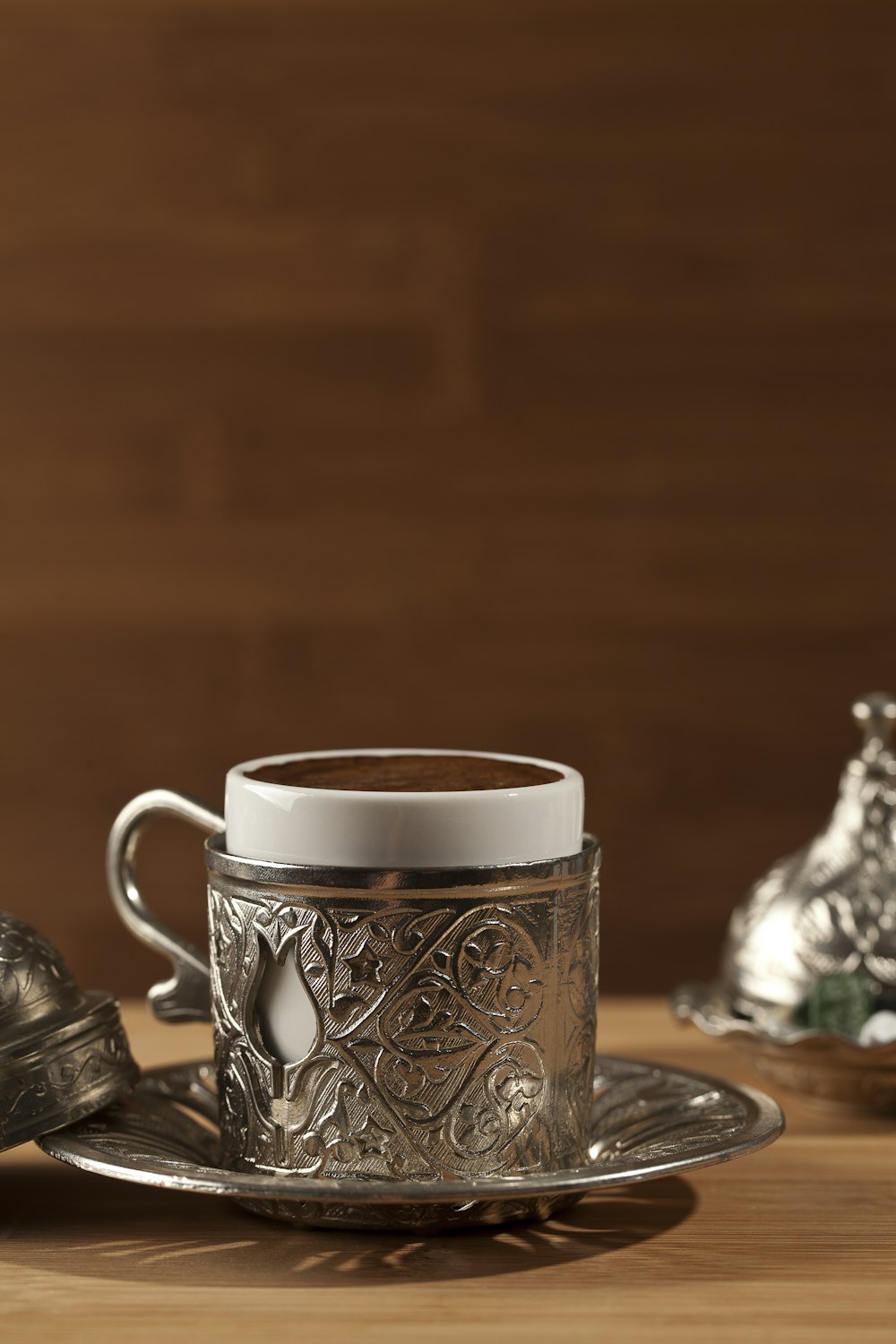 white and black floral ceramic mug on table
