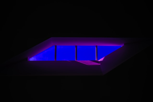 A sleek, modern room bathed in animated amber and indigo glow gradients, showcasing smart ambient lighting in action.
