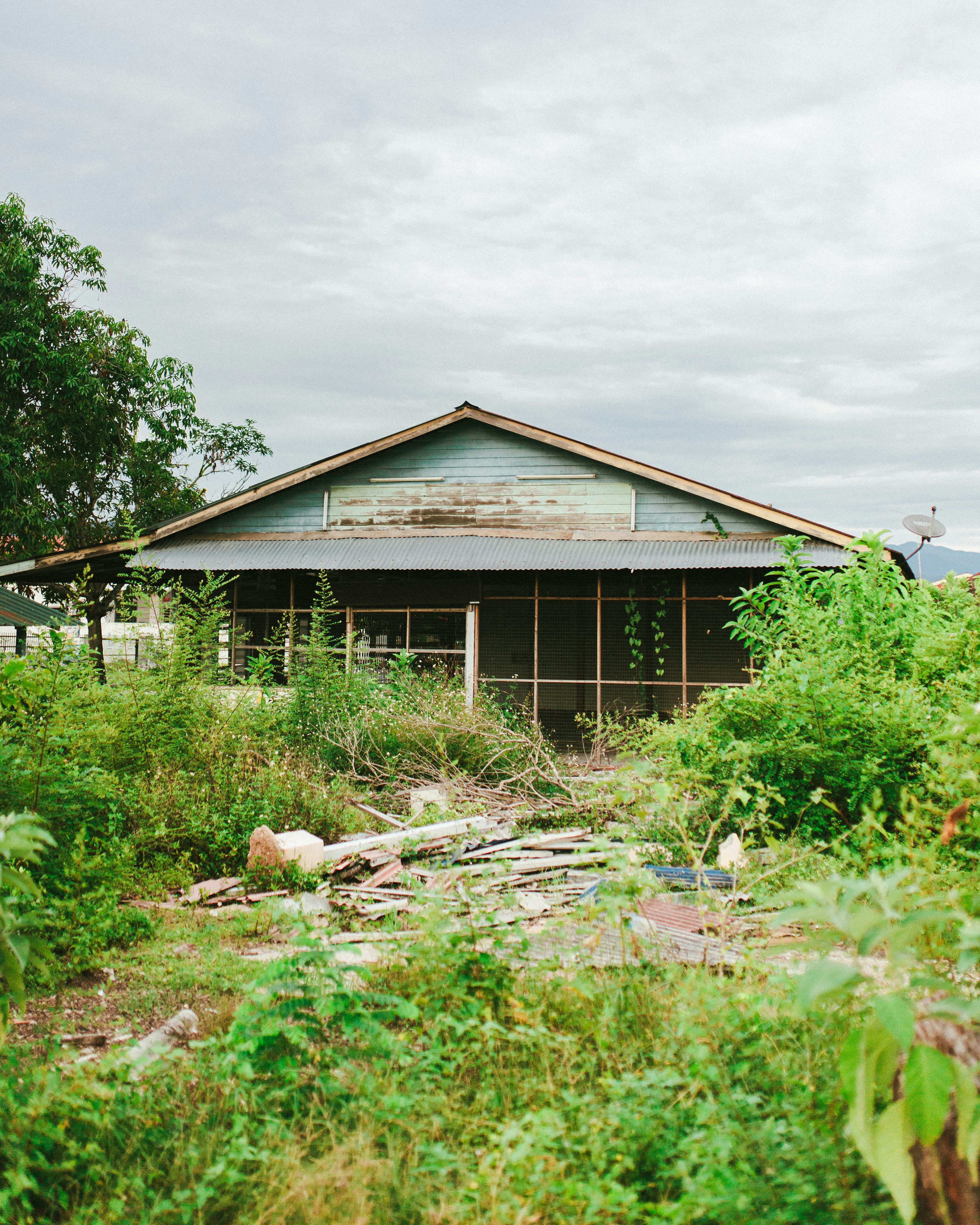 brown wooden house near green grass field during daytime