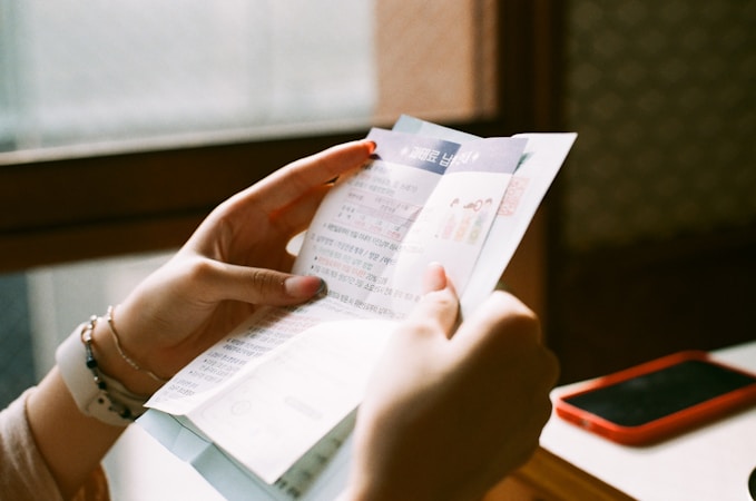 A person holding a printed utility bill and reviewing the charges at home